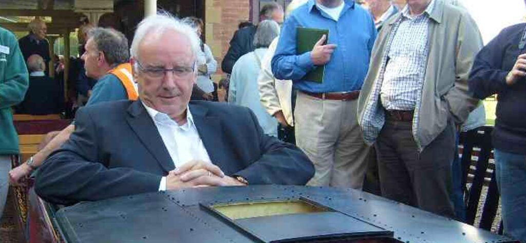 Pete Waterman sat in a miniature train